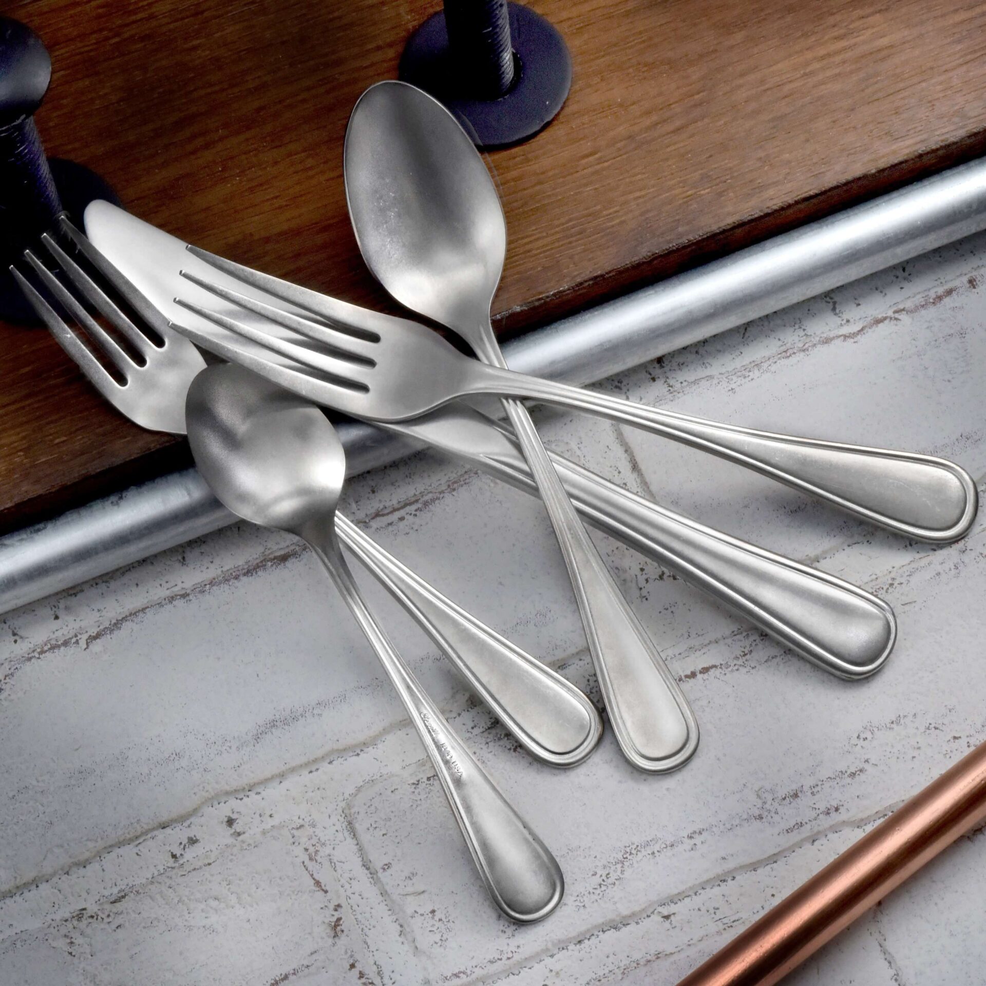Industrial Rim Spoons and Fork Set on a Surface