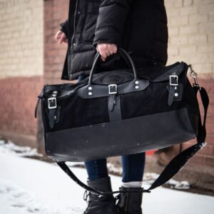 A Woman Carrying a Black Sportsman Duffle Bag